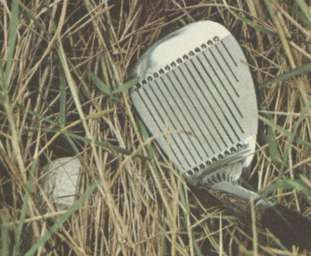 sand wedge next to buried ball in the rough